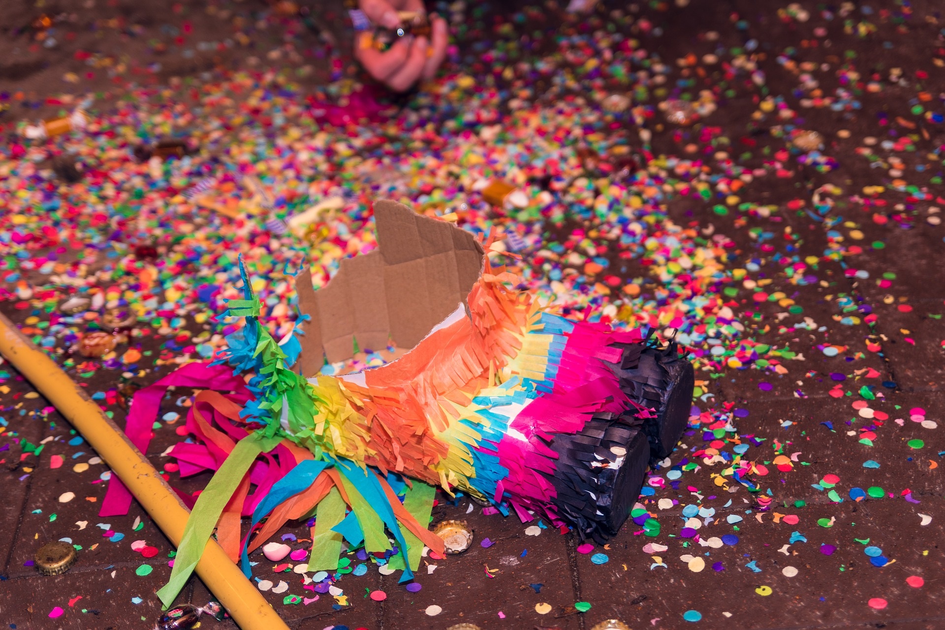 Picture of a broken pinata with confetti splilled on the ground.