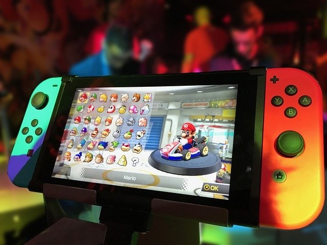 Picture of a Nintendo Switch video game console with a graphic of Mario Kart on the screen.