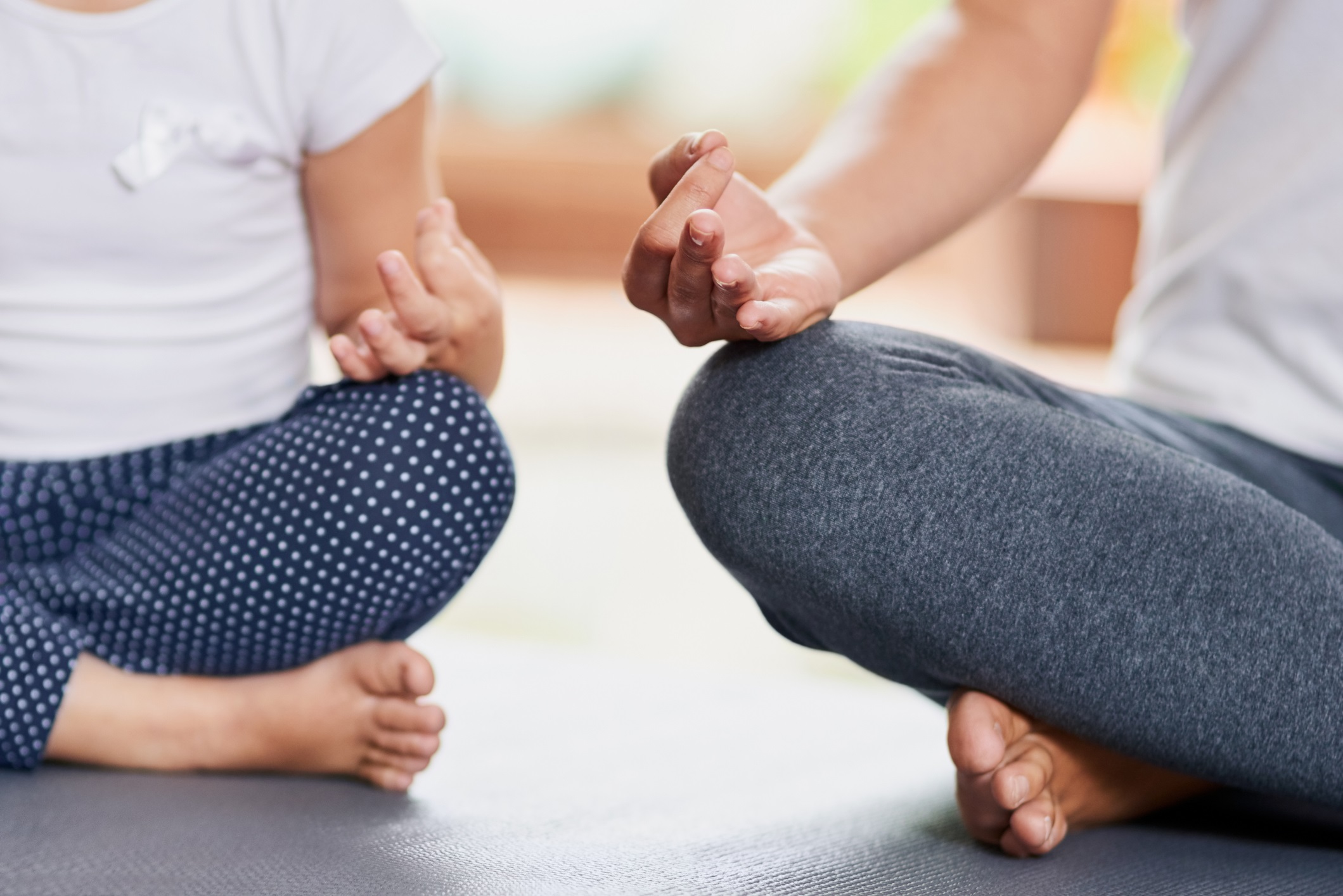 An adult and child meditating. 