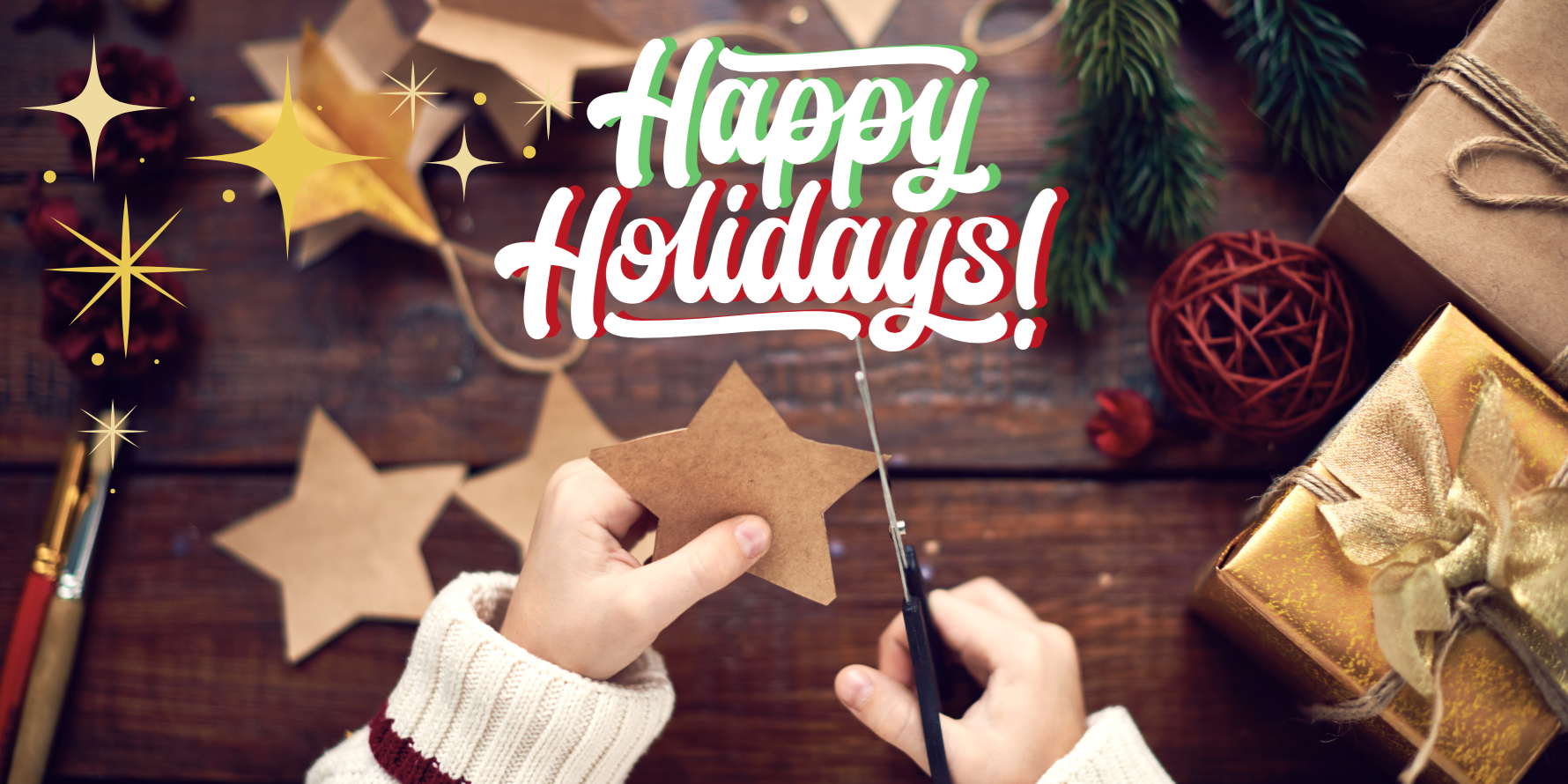 A person cutting a star shape with the text "Happy Holidays."