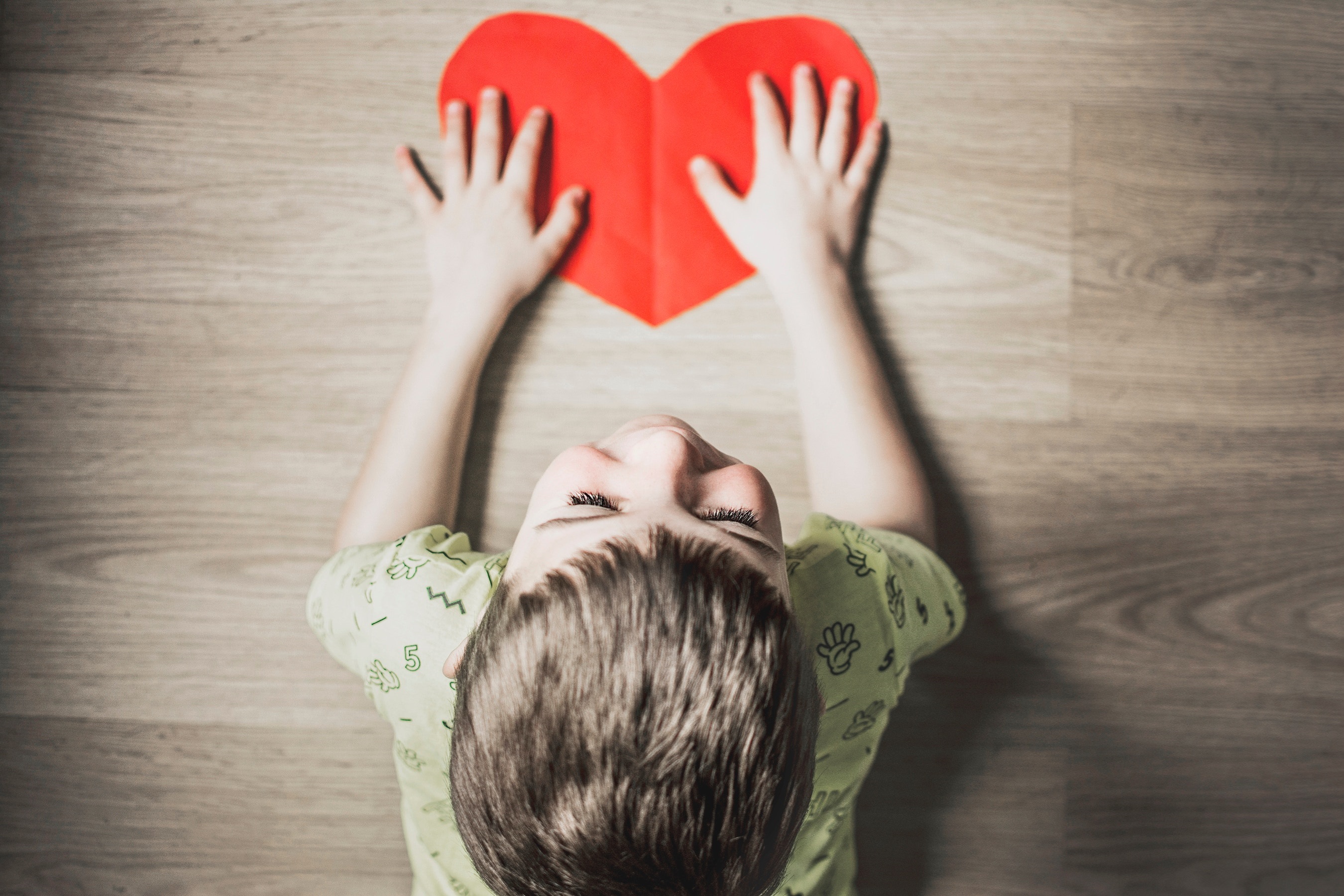 Child's Hands Over Red Heart