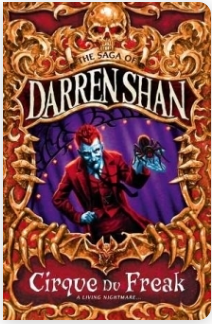 Book cover for Cirque du Freak: A Living Nightmare by Darren Shan. A red-haired man with a red suit displays a large strange-looking spider on stage. His image is framed by golden bones and a skull.