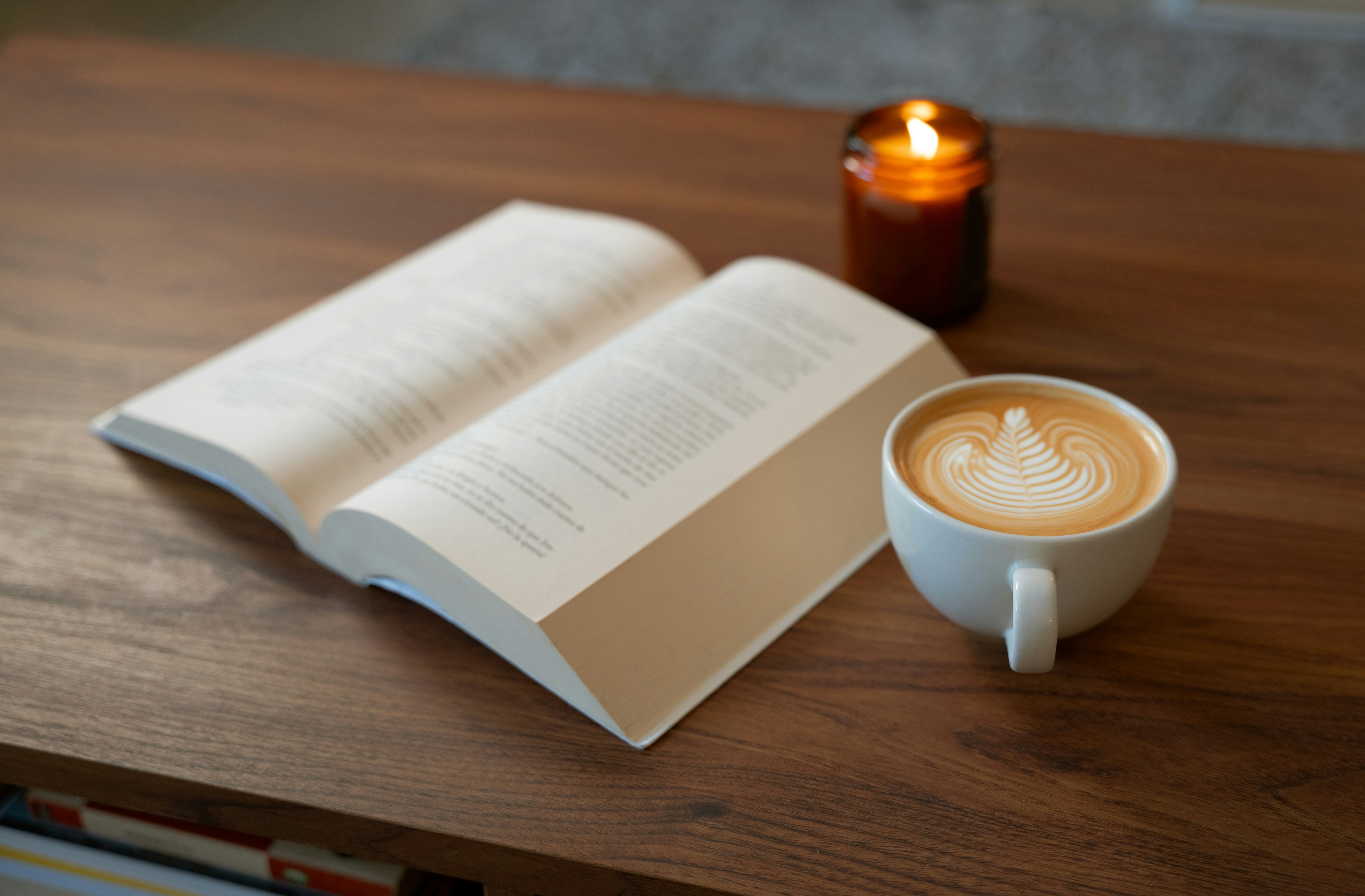 Open Book on Table with Candle and Coffee Mug