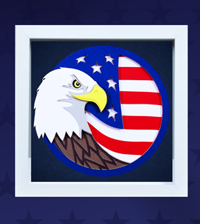 A shadowbox with layers of colored paper making a bald eagle and American flag design