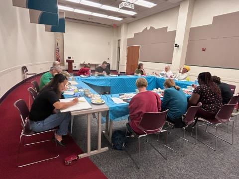 People at a table creating art.