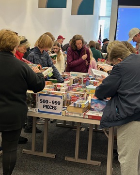 Group of people selecting from an assortment of puzzles