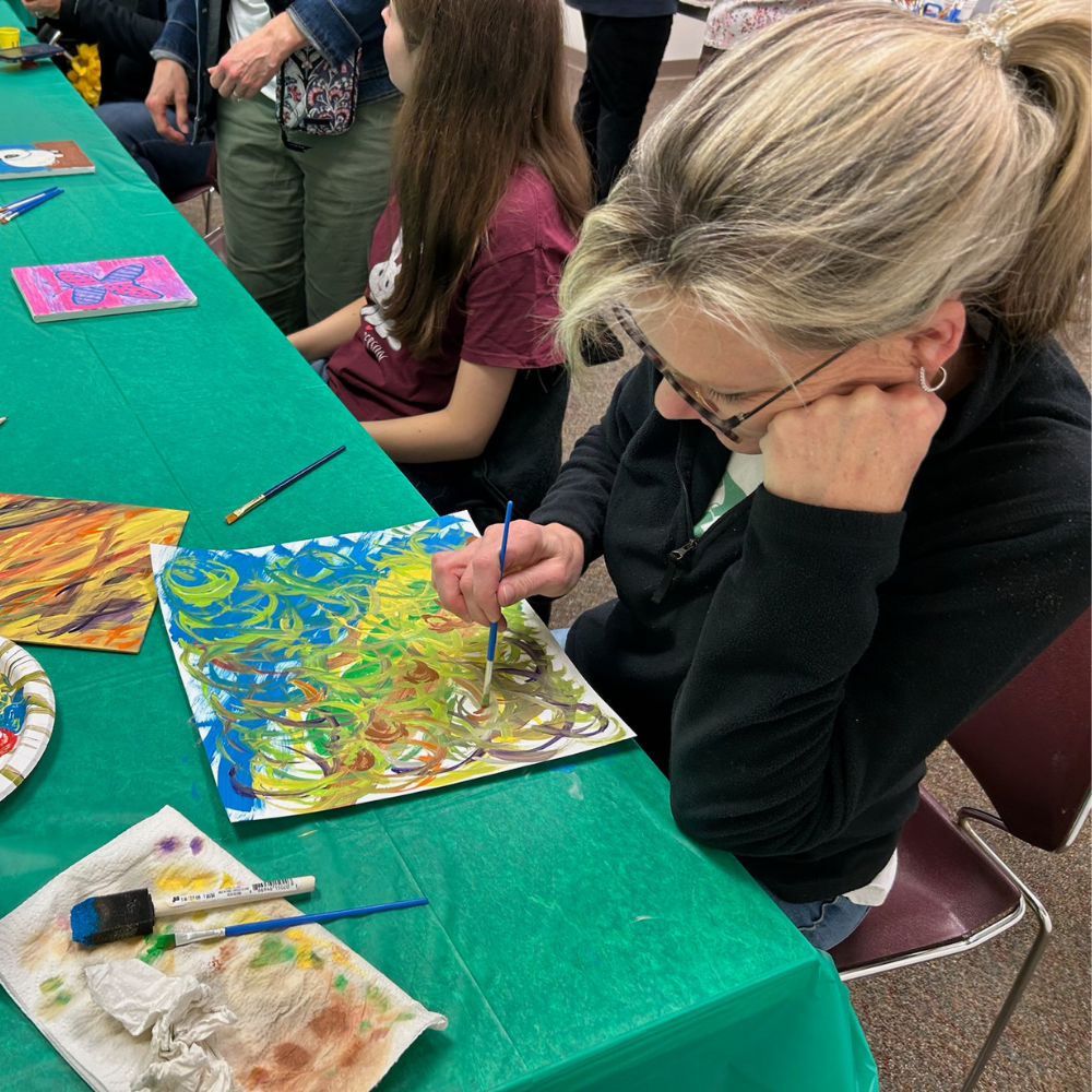 A woman using a paintbrush to create an original artwork