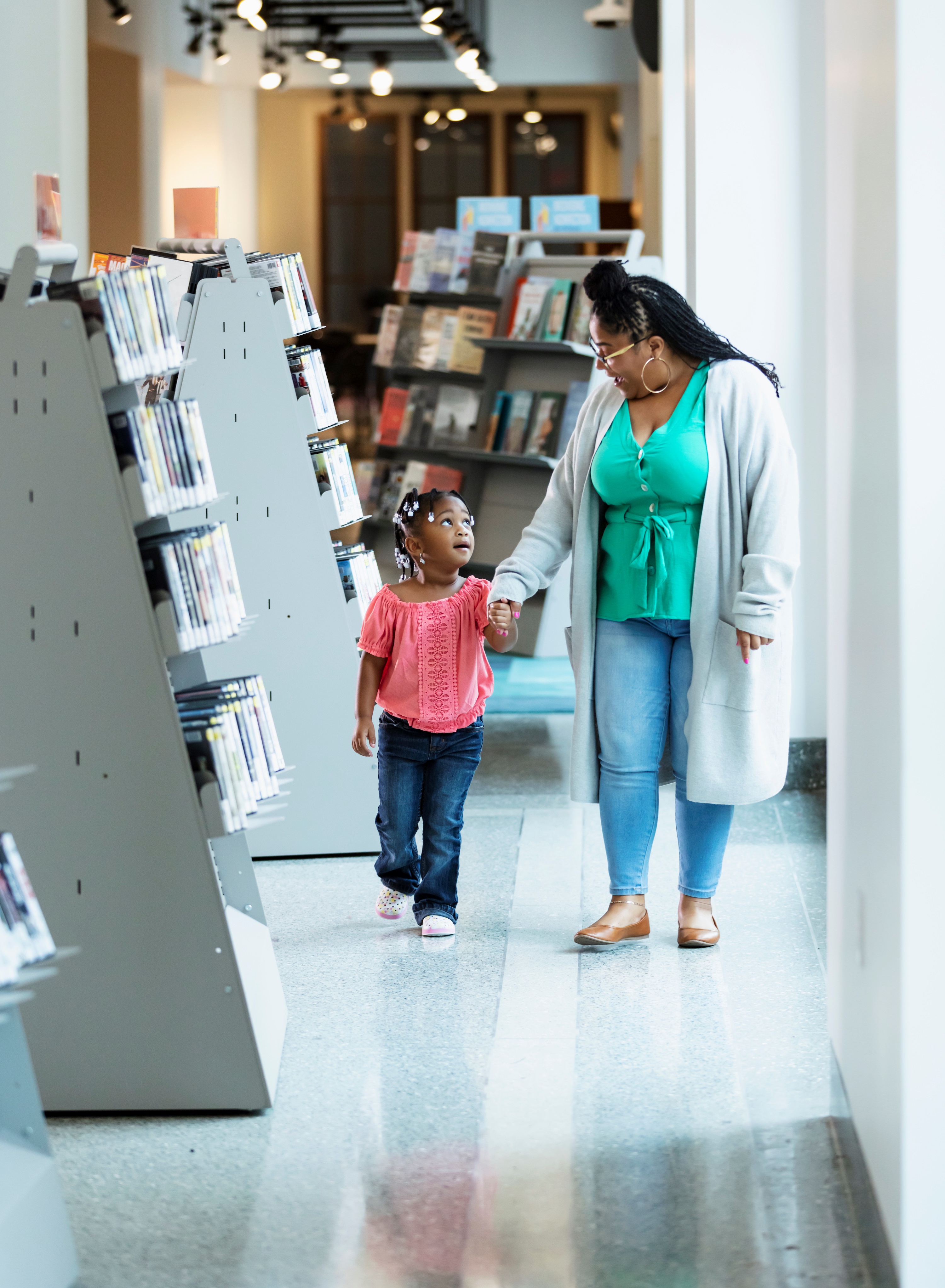 Mother and Daughter Walking in Public Library