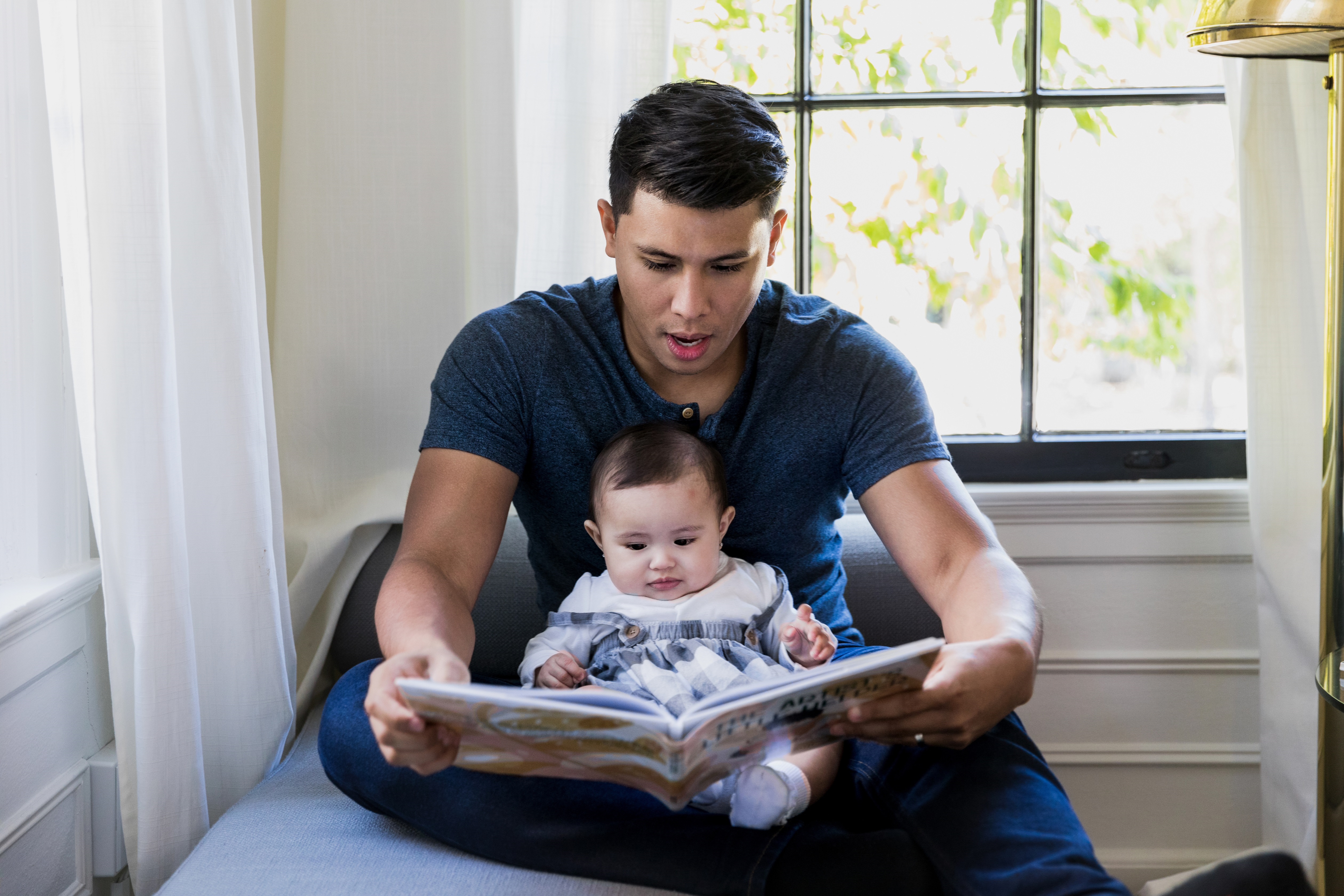 Father Reading a Book to his Baby
