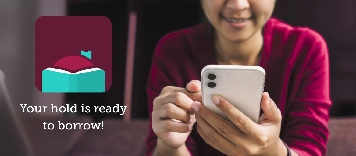 Picture of a person holding their phone and looking at it. On the right is the Libby app icon and the text "Your hold is ready to borrow!"