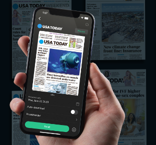 A hand holding a phone showing USA Today in the PressReader app