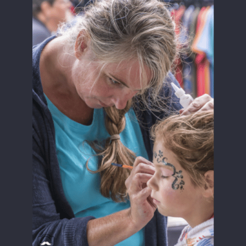 Woman painting a child's face
