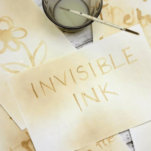 Paper with message "Invisible Ink" barely visable,