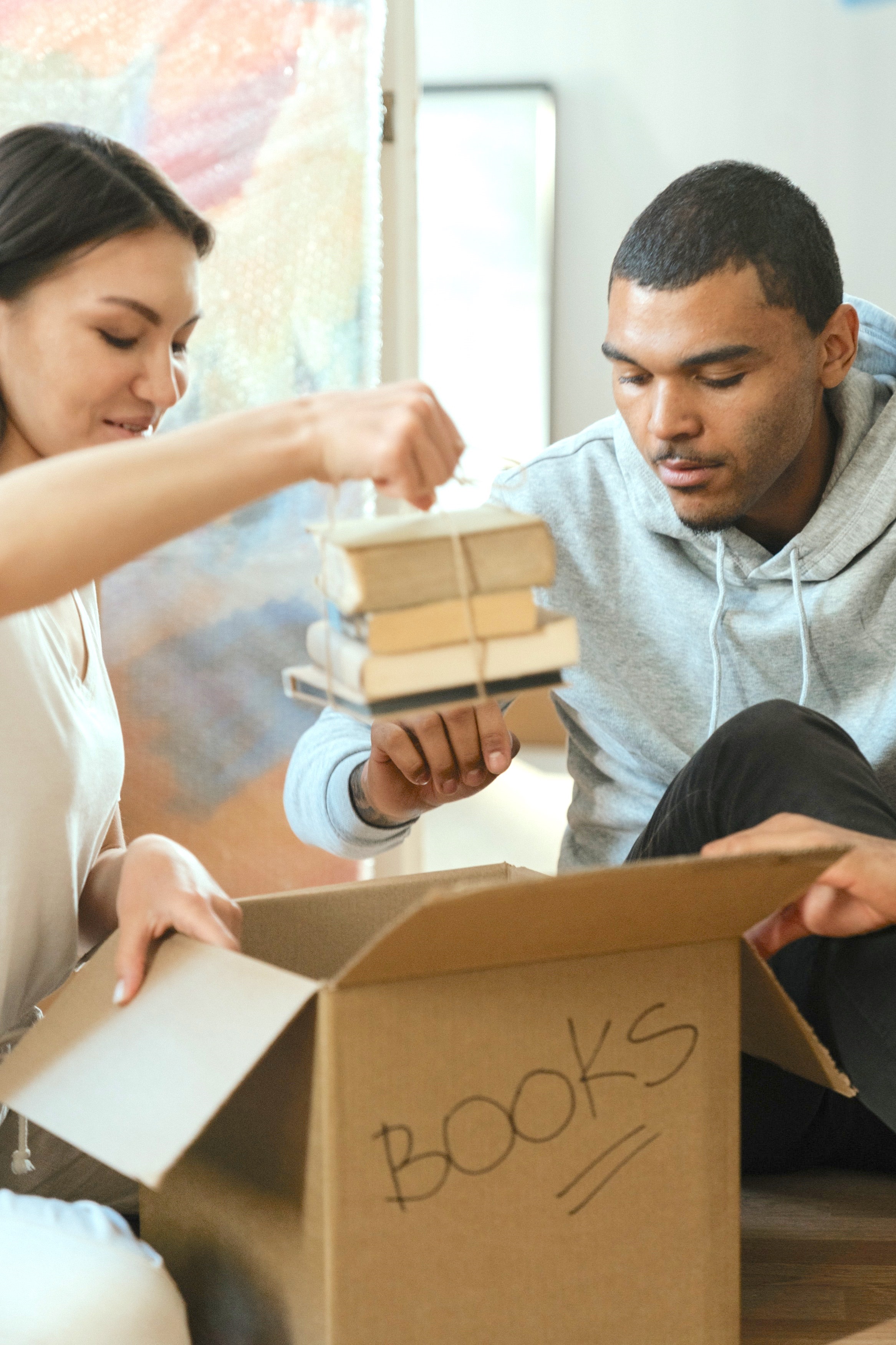 Two People Packing Books in a Box