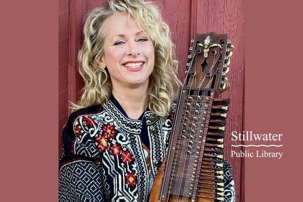 Musician, in a Norwegian sweater, with a Nyckelharpa