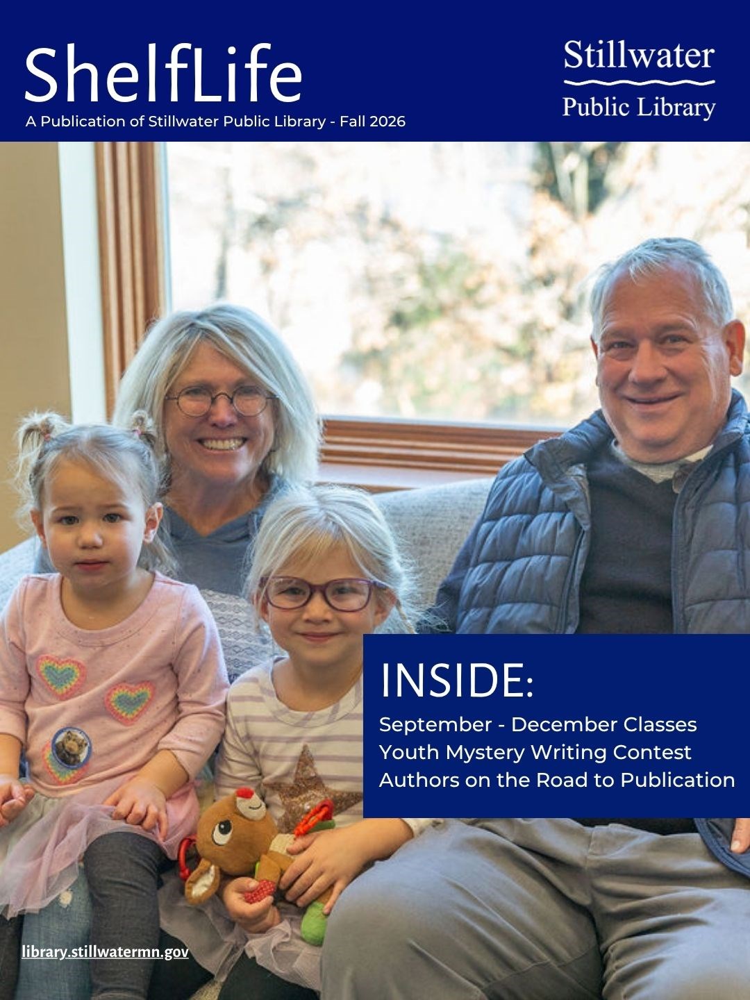 Grandparents with two grandchildren sitting on couch in library