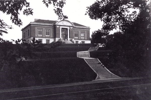Historical black and white photo of Stillwater Public Library from 3rd Street showing elevation and extensive multi-level stairs