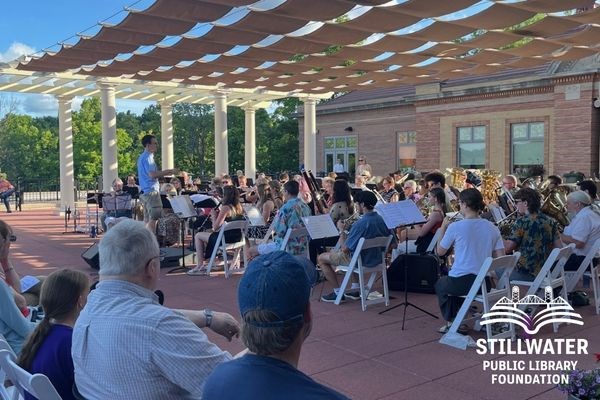 Audience watching a symphony band on library terrace
