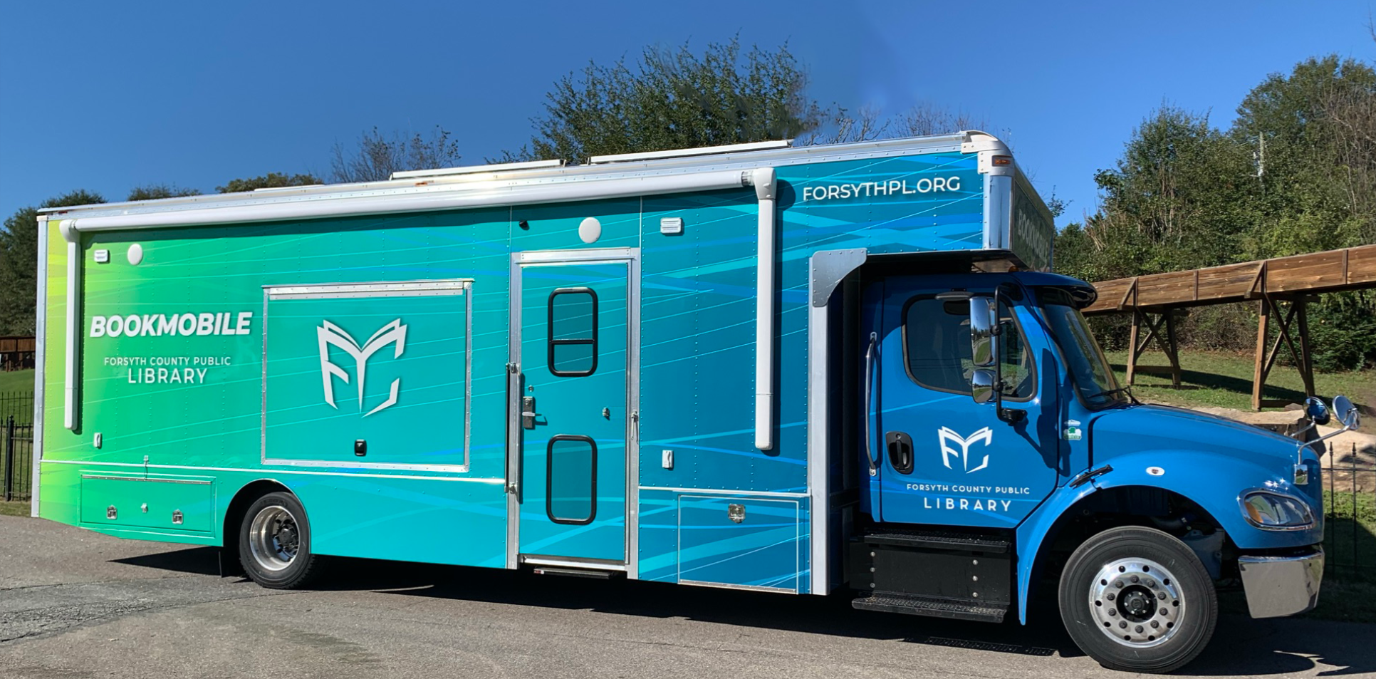 A mixed-age crowd of people with happy and surprised faces as they watch a magic show at the Post Road Library.