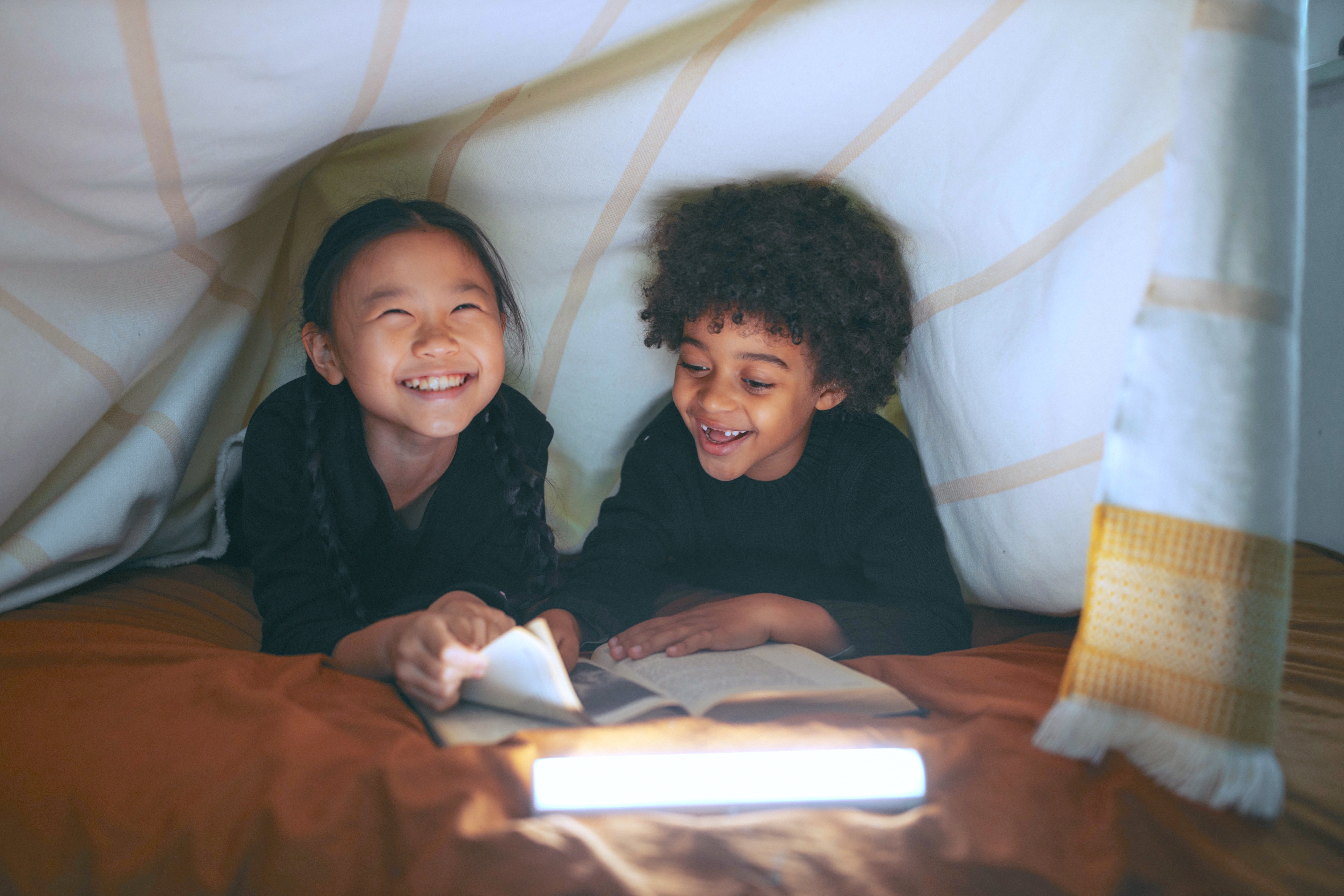 Girl And Boy Having Fun While Reading A Book