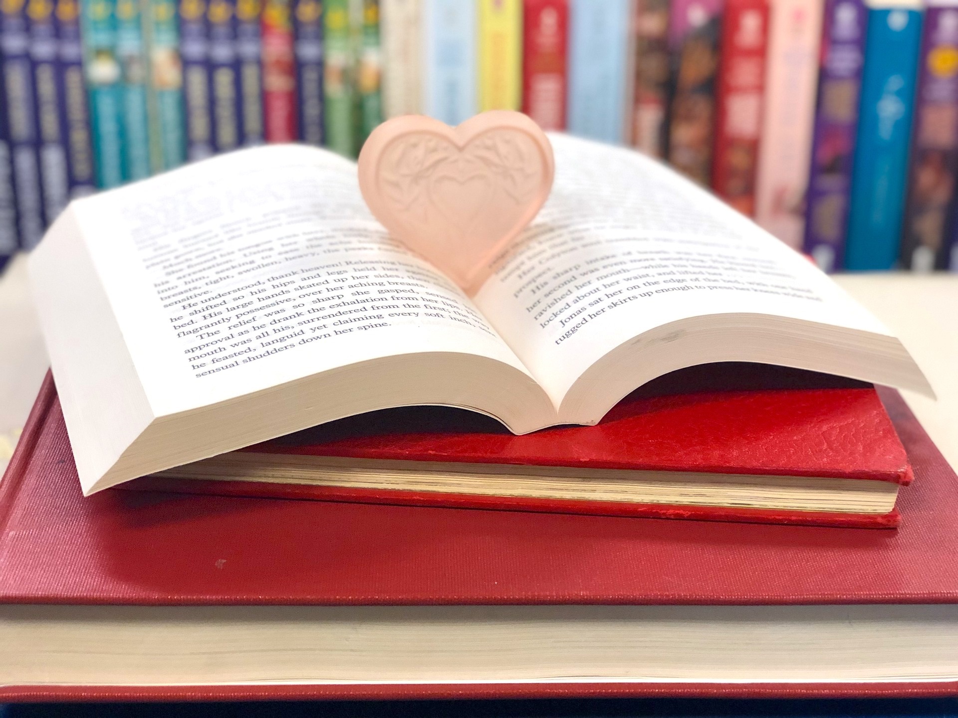 open book on a table with a small heat balanced on it