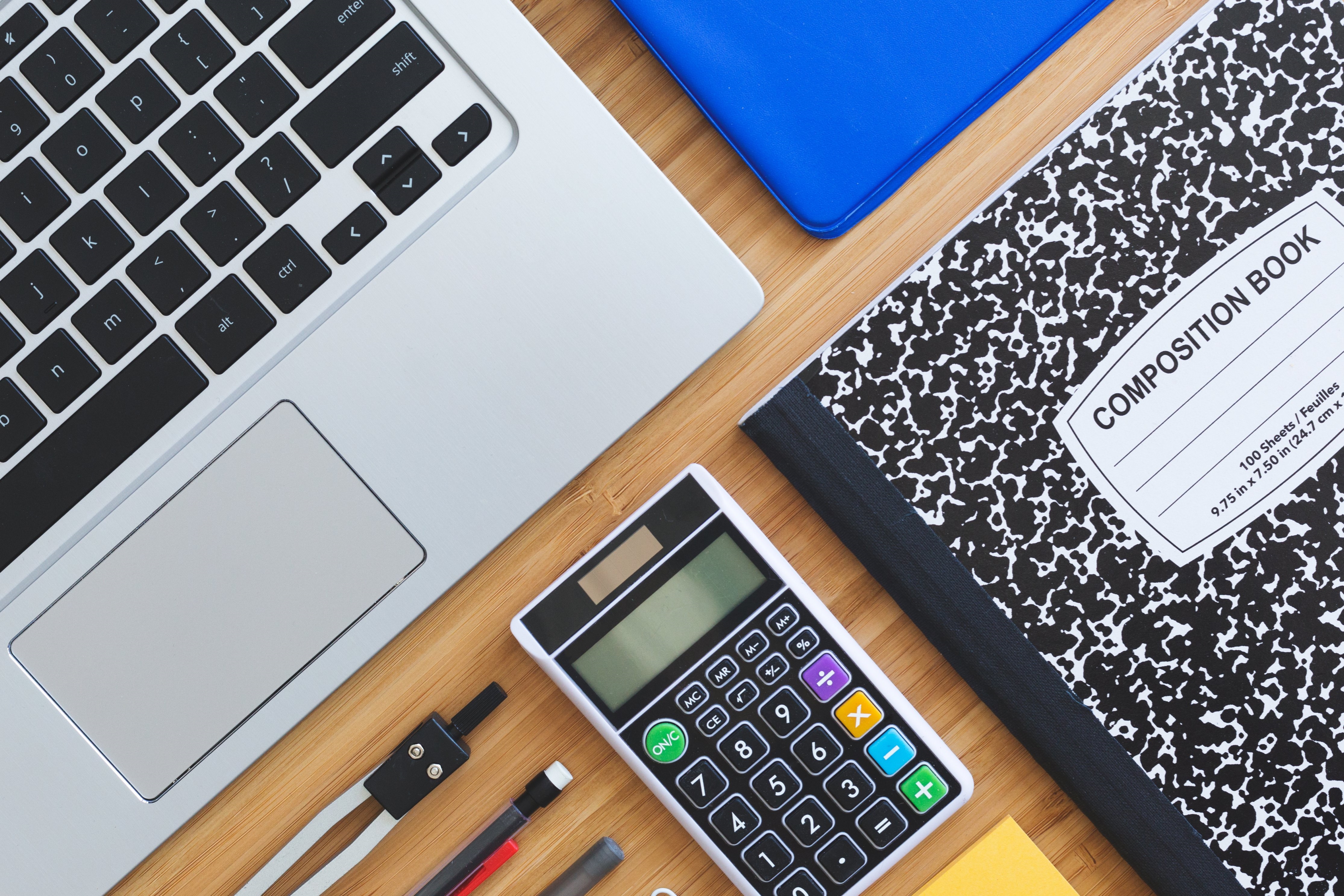 Close Up of Laptop Calculator and Notebooks