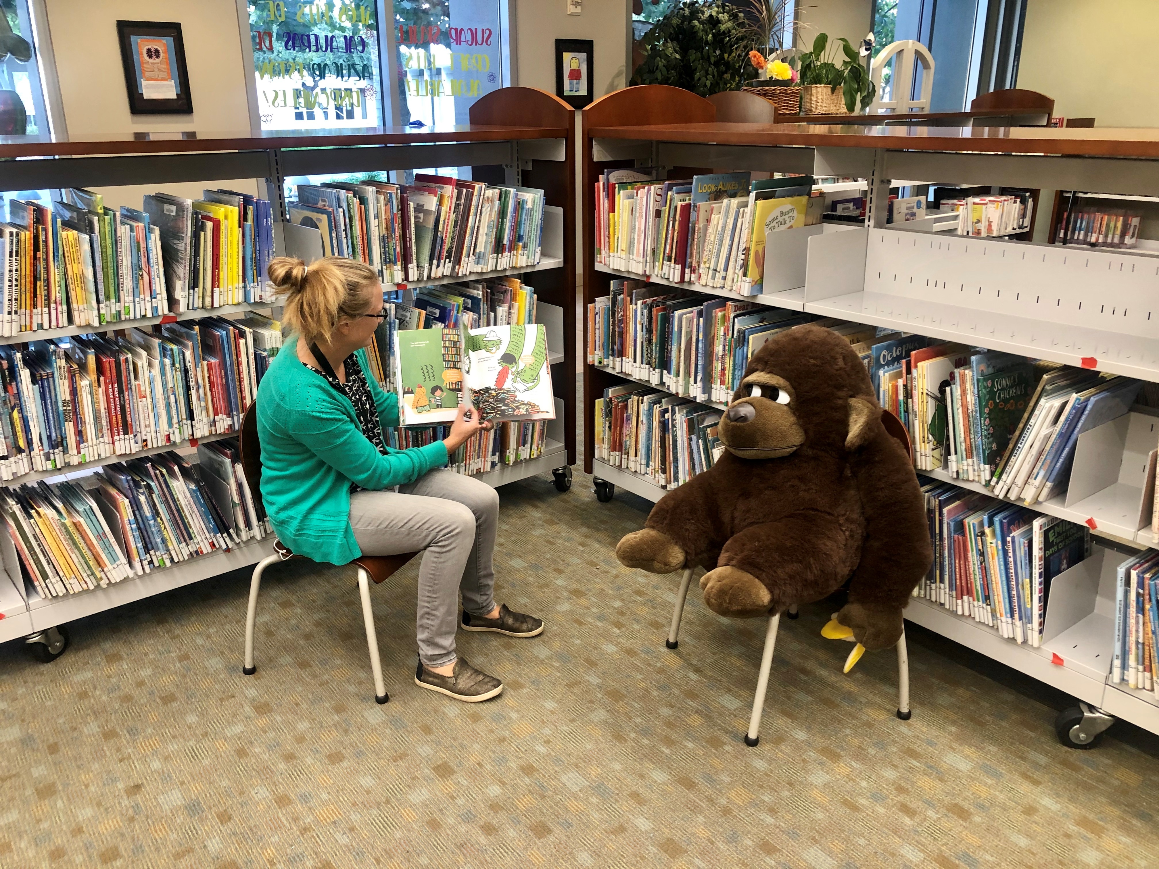Librarian reading to a gorilla plush