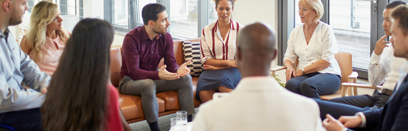 A group of people sitting in a circle having a conversation.