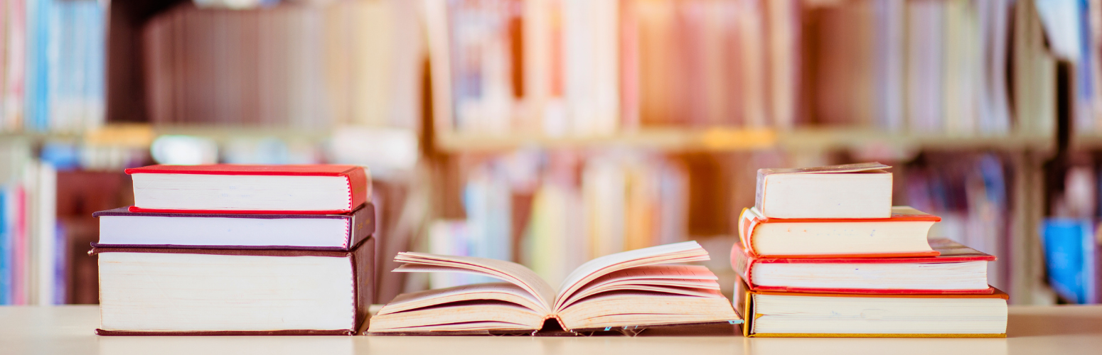 Two stacks of books on either side of an open book.