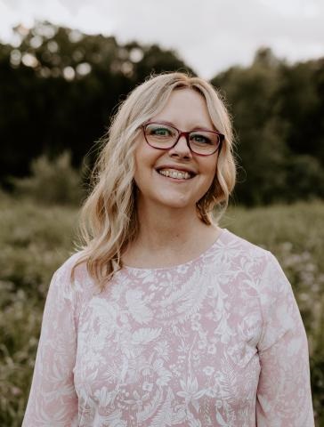 A woman with long hair and glasses