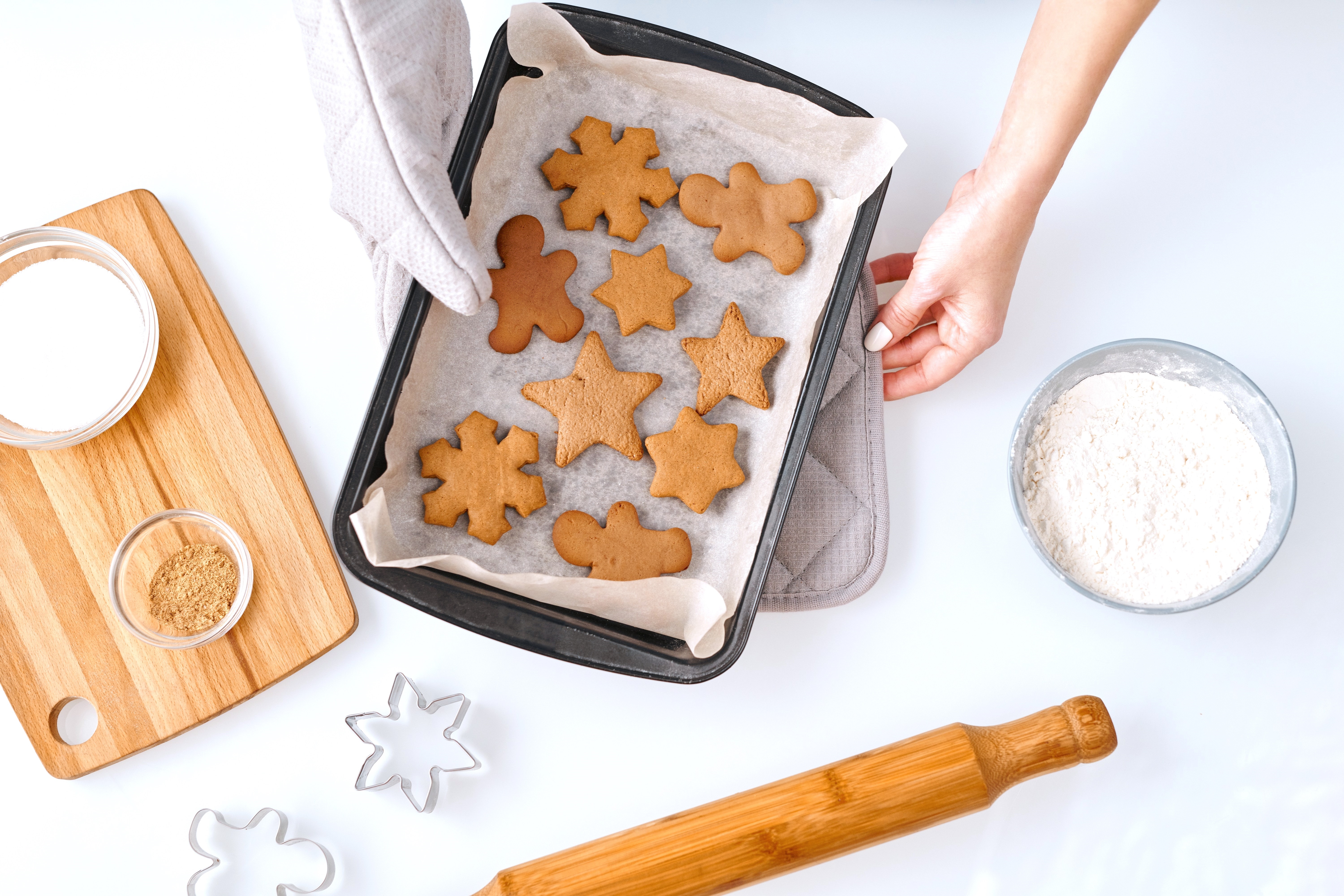 Person with Baking Sheet of Gingerbread Cookies