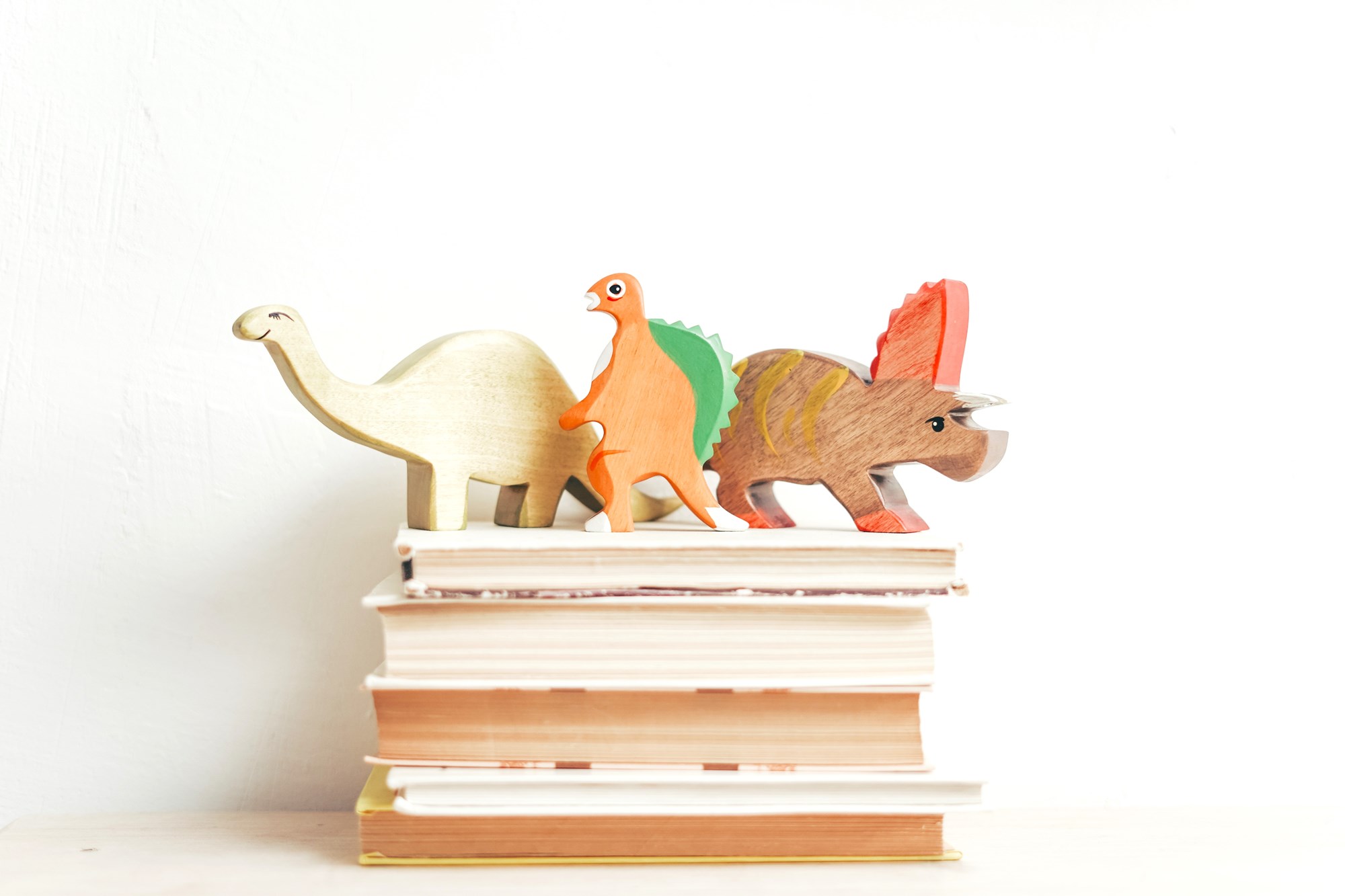Toy Dinosaurs on Stack of Kids Books