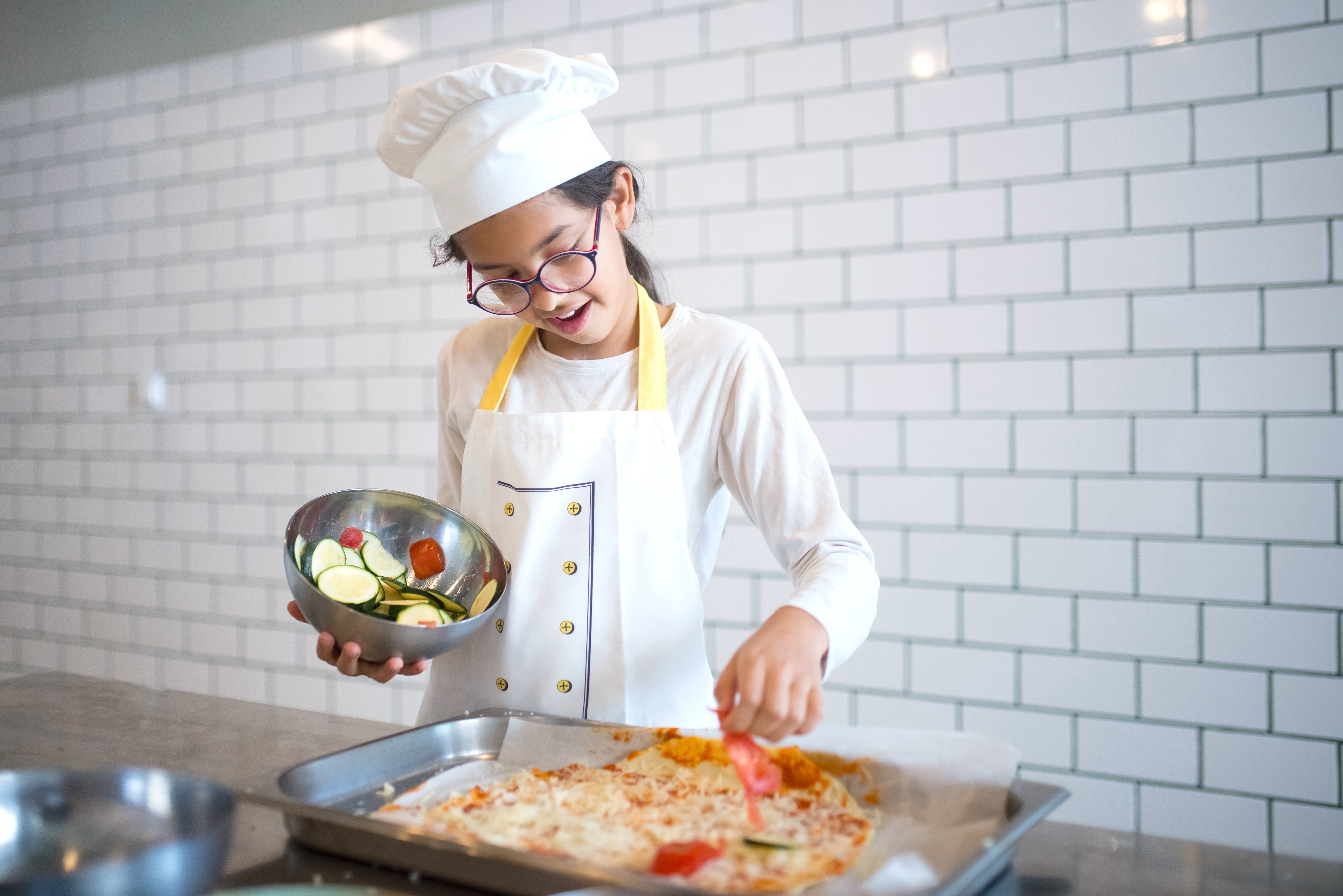Girl in Apron and Chef Hat Cooking in a Kitchen