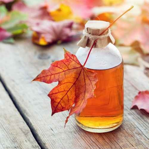 A bottle of maple syrup with a leaf.