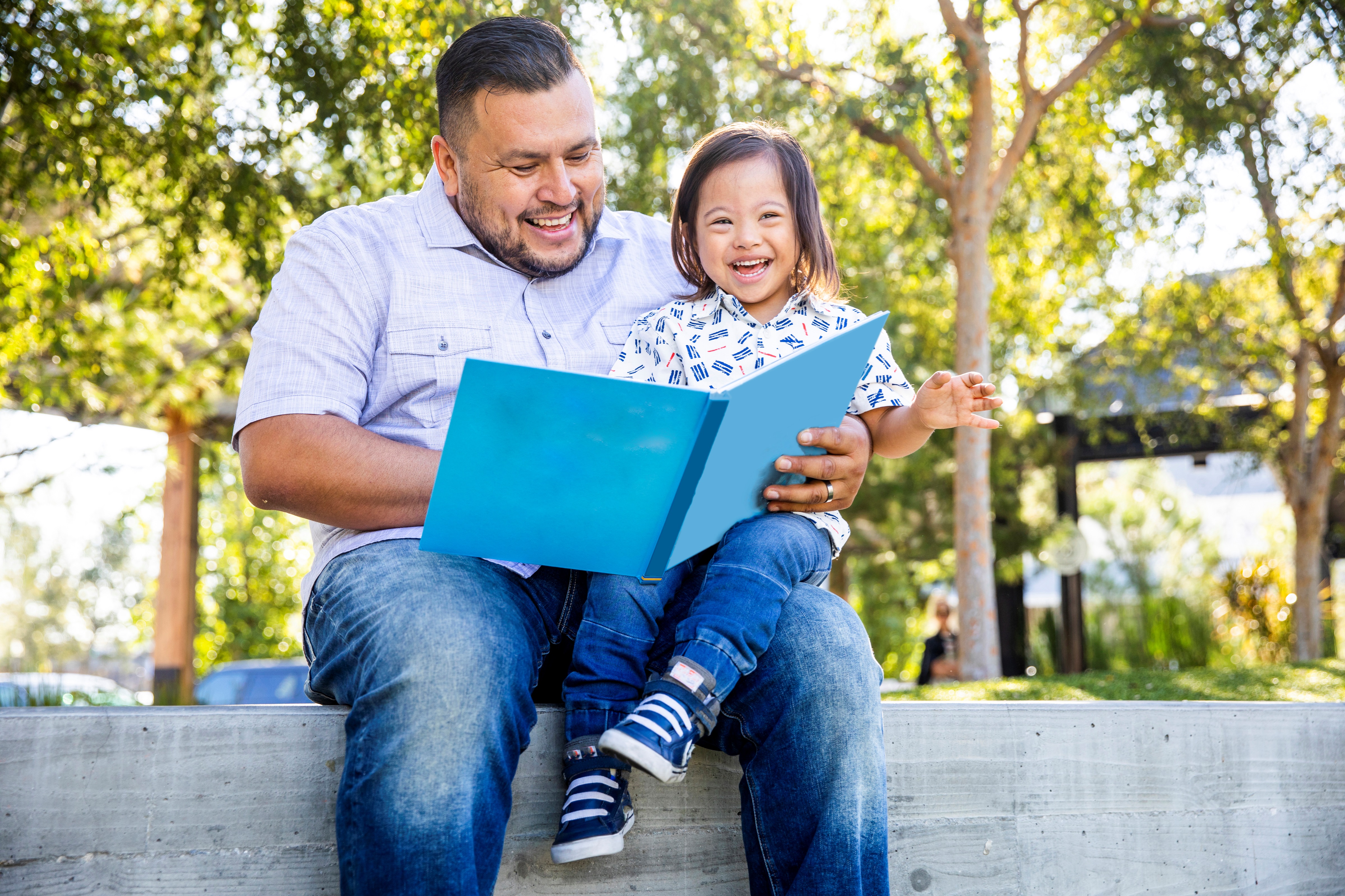 Man and Child Reading Blue Book
