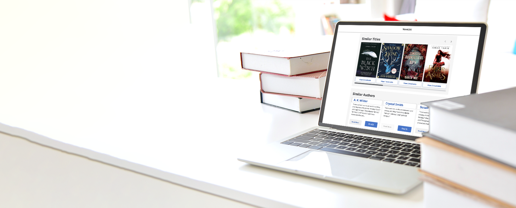 laptop surrounded by books