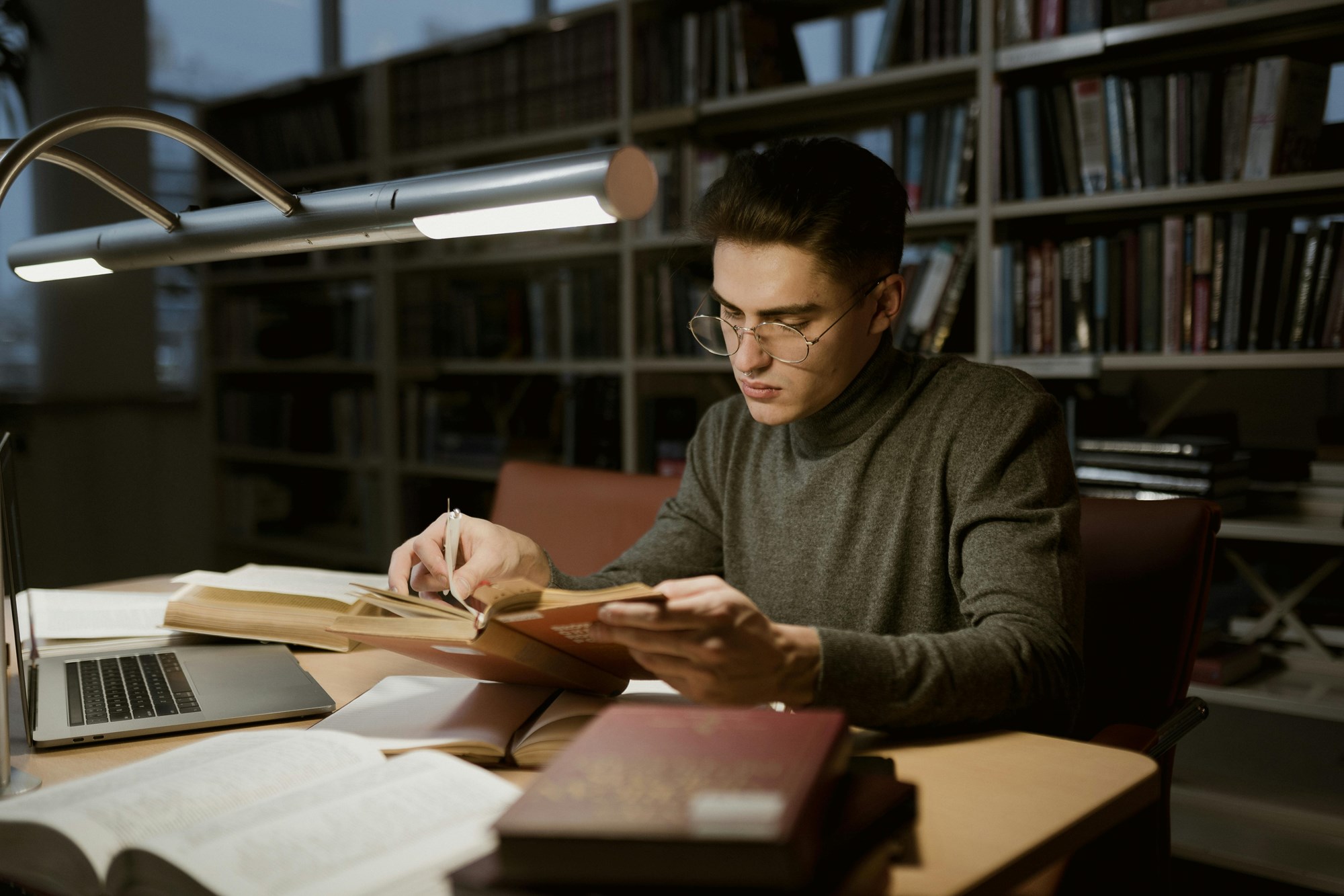 A Man Reading a Book in a Library A Man Reading a Book in a Library