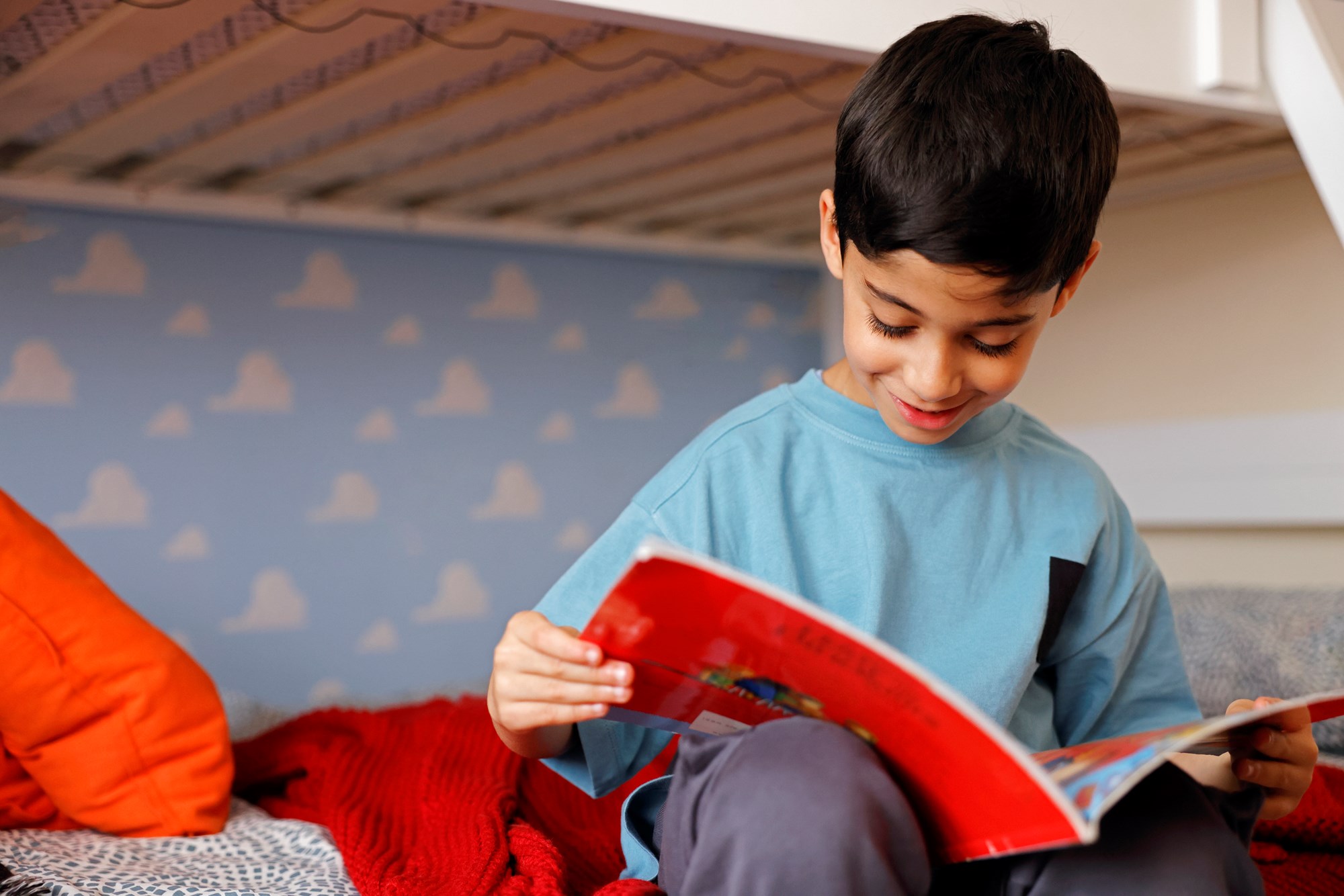A Young Boy Reading a Book at Home in his Bedroom