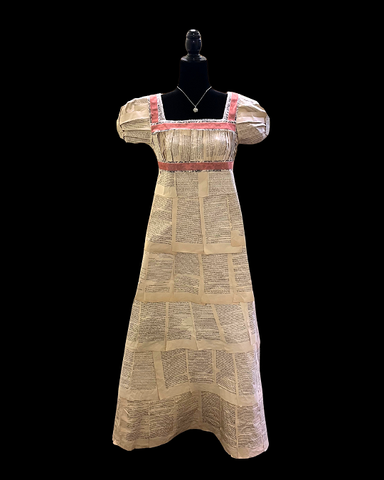 Regency-era dress made of book pages with pink collar and waist trim on a dress stand
