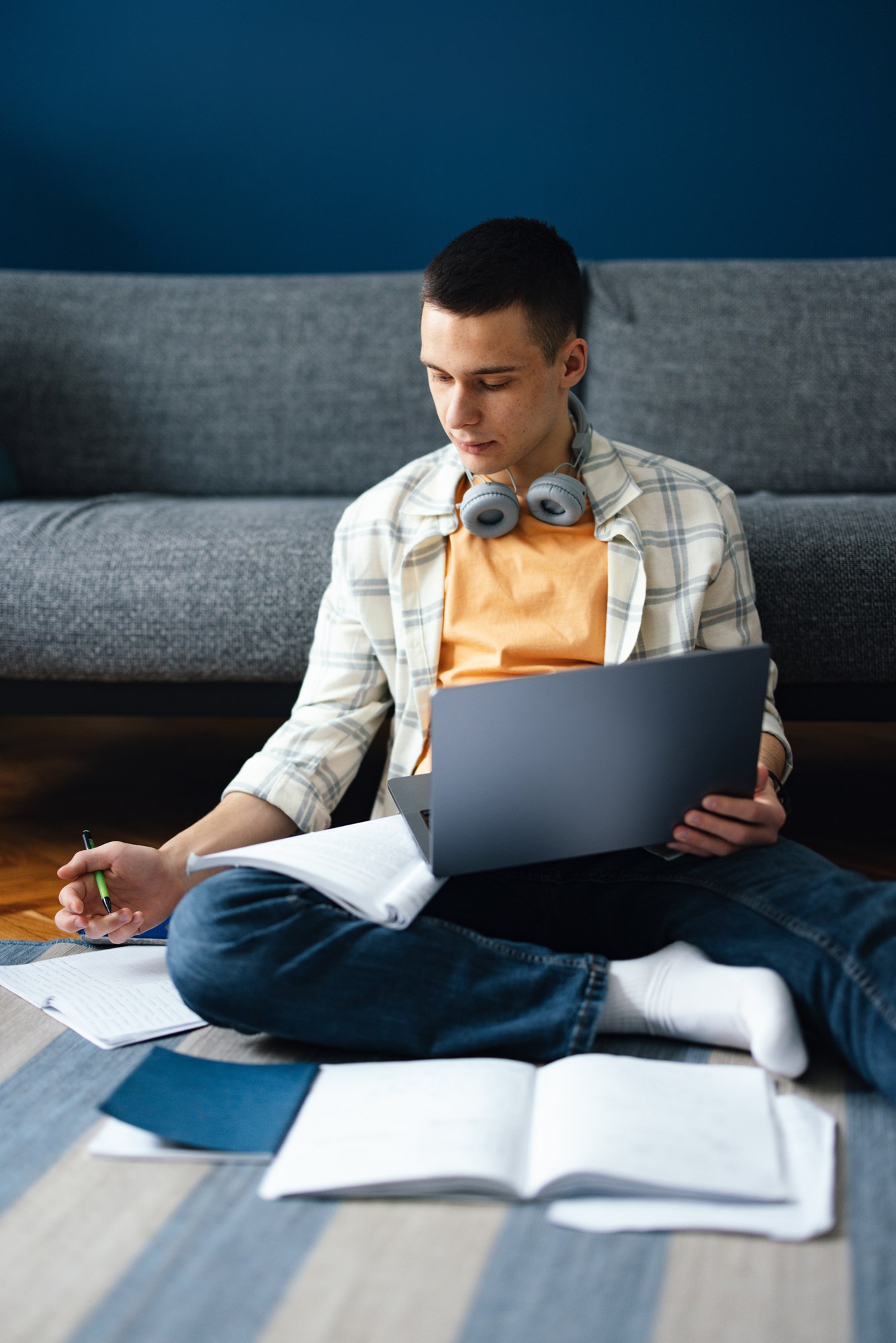 Happy Teenage Boy Using A Laptop Computer At Home