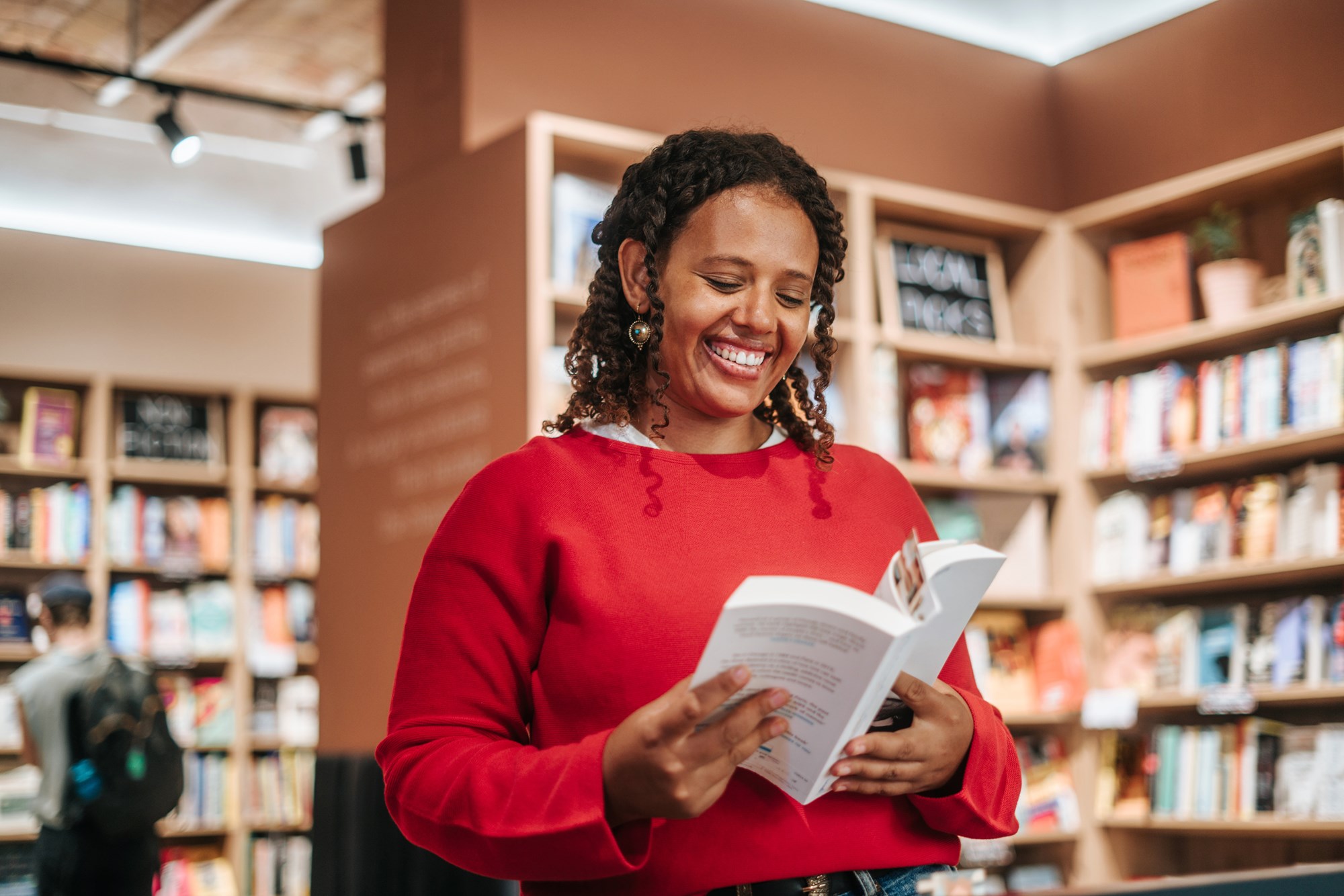 A Smiling Woman Buying Books At Store