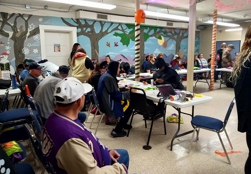 group of people sitting at tables for a library craft event