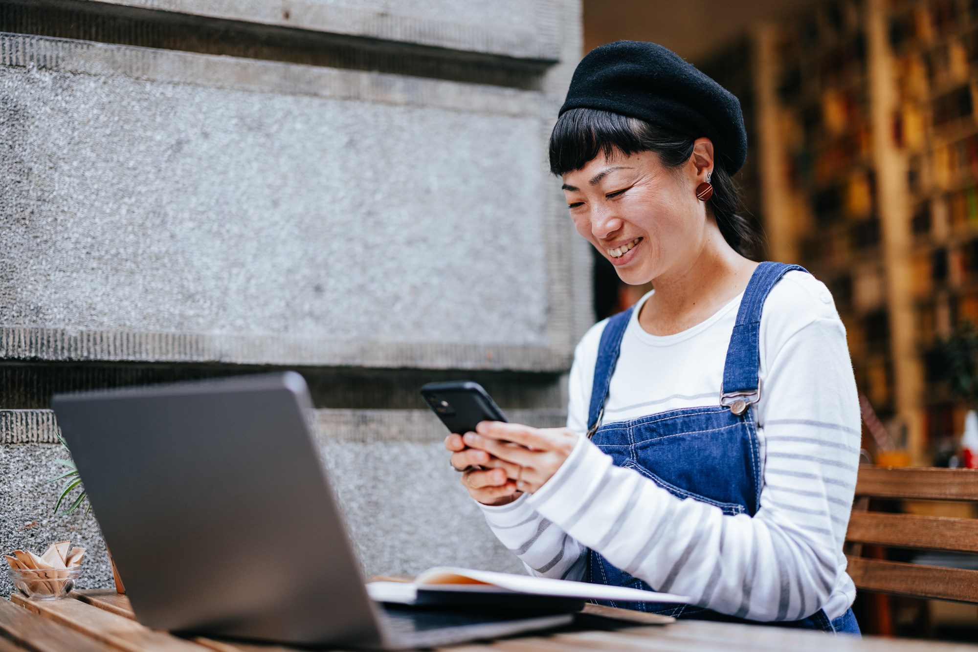 Woman Using a Mobile Phone in an Outdoor Cafe 