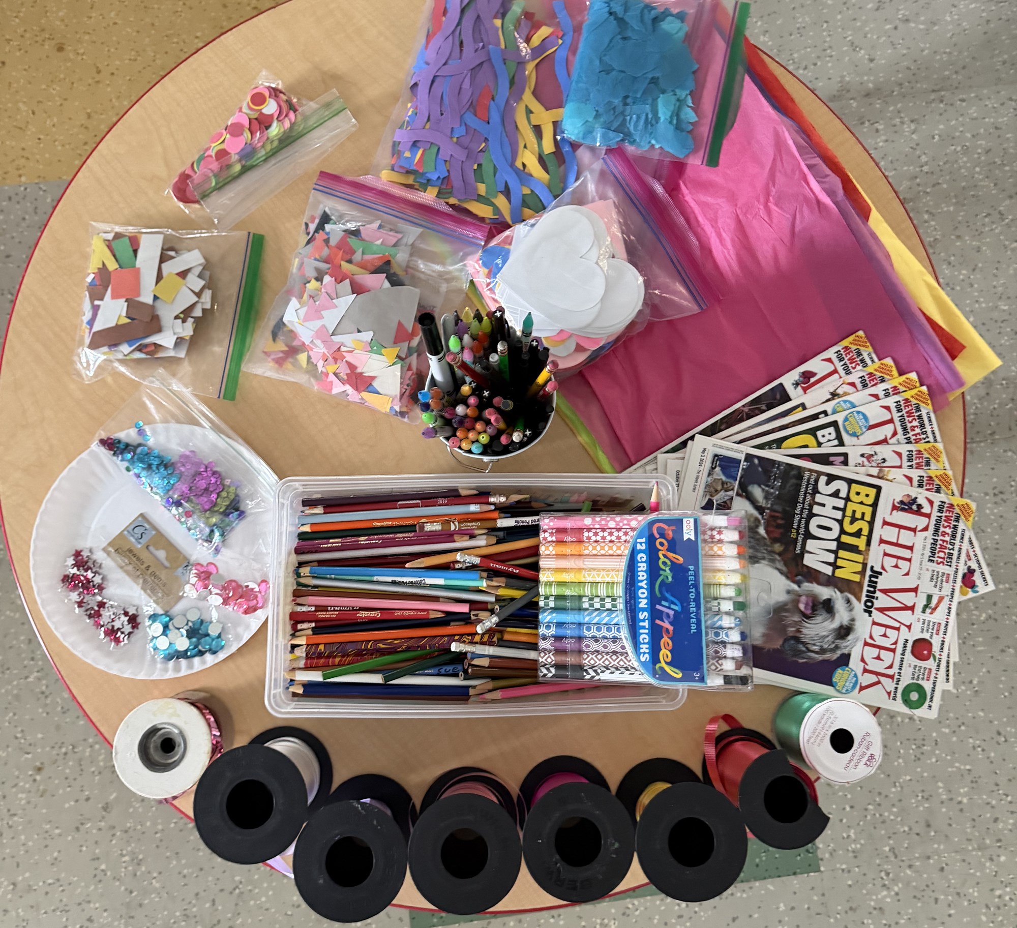 Various art supplies on a round table.