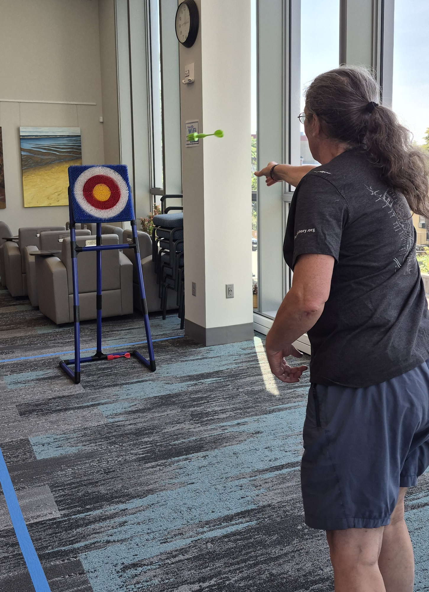 A patron throwing an axe at the Axe Throwing station during the Kickoff Party.