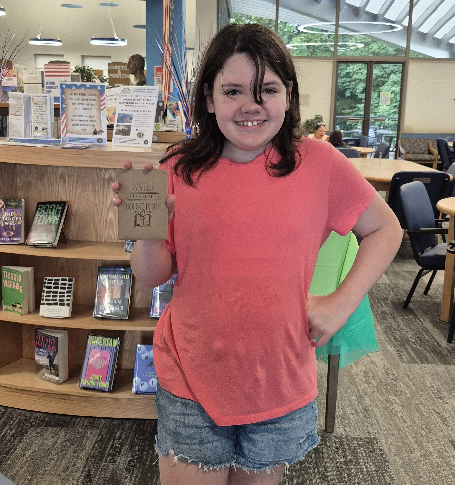 A prize winner posing with their Water Street Bookstore gift card.