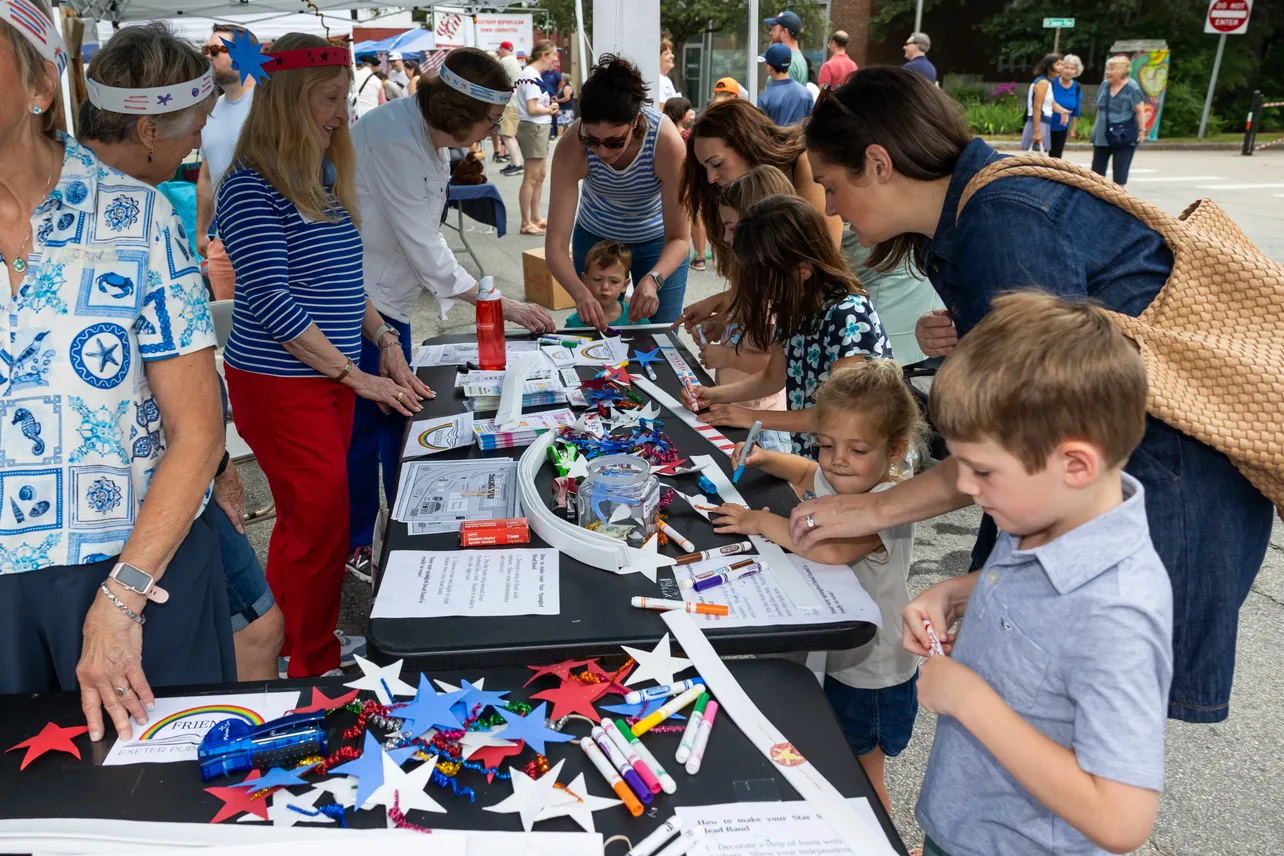 Festival goers make the headband at the Friends of EPL booth.