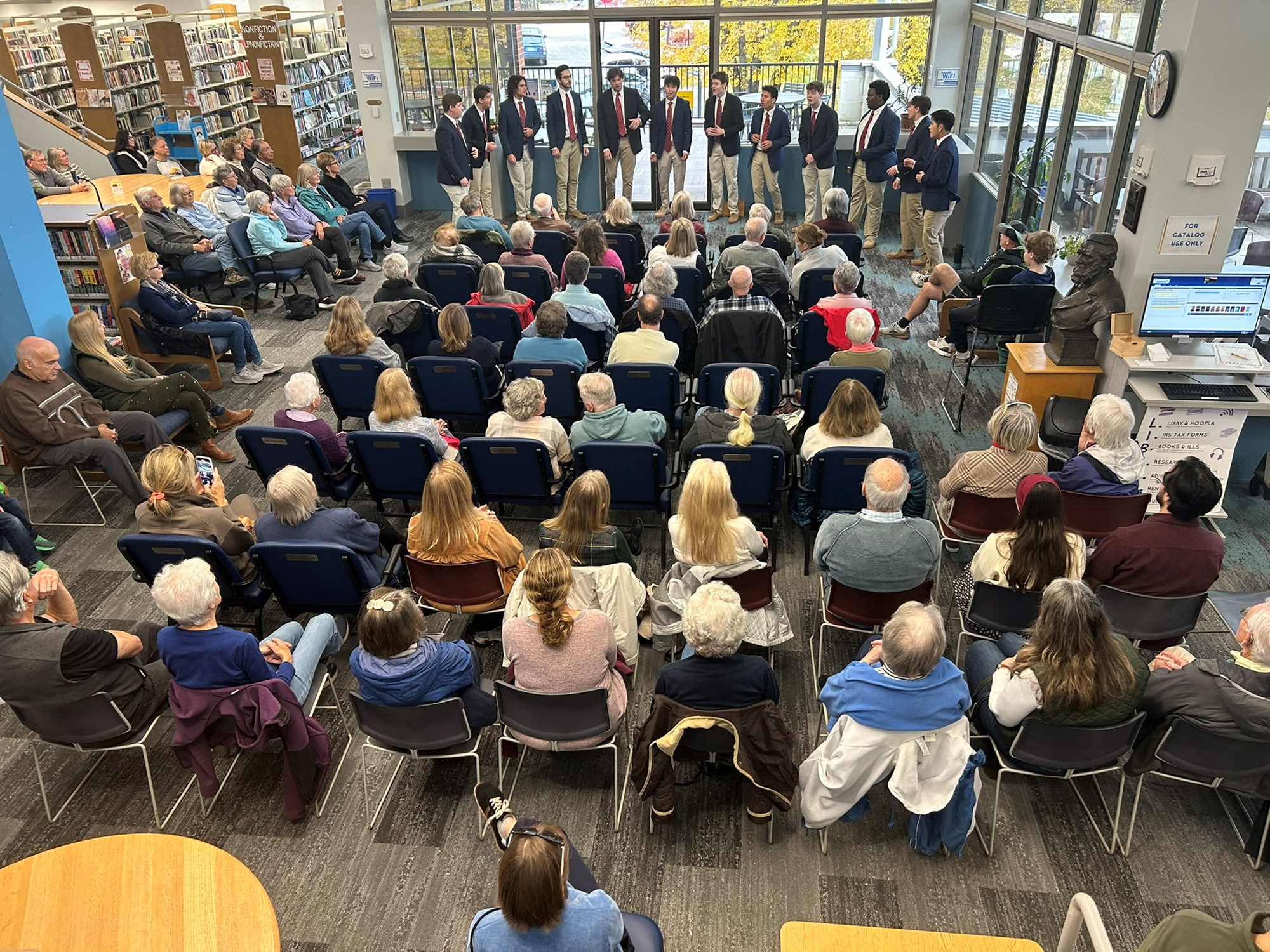 Colgate Thirteen performing in the main seating area of the library.