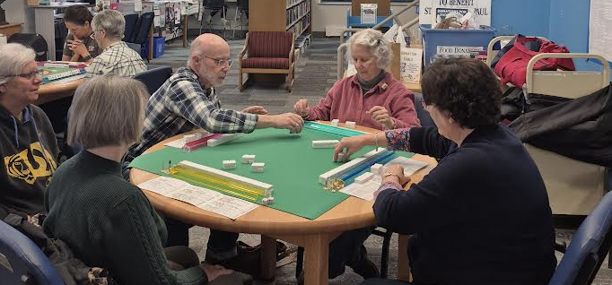 A group of five playing Mah Jongg on the main floor of the library.