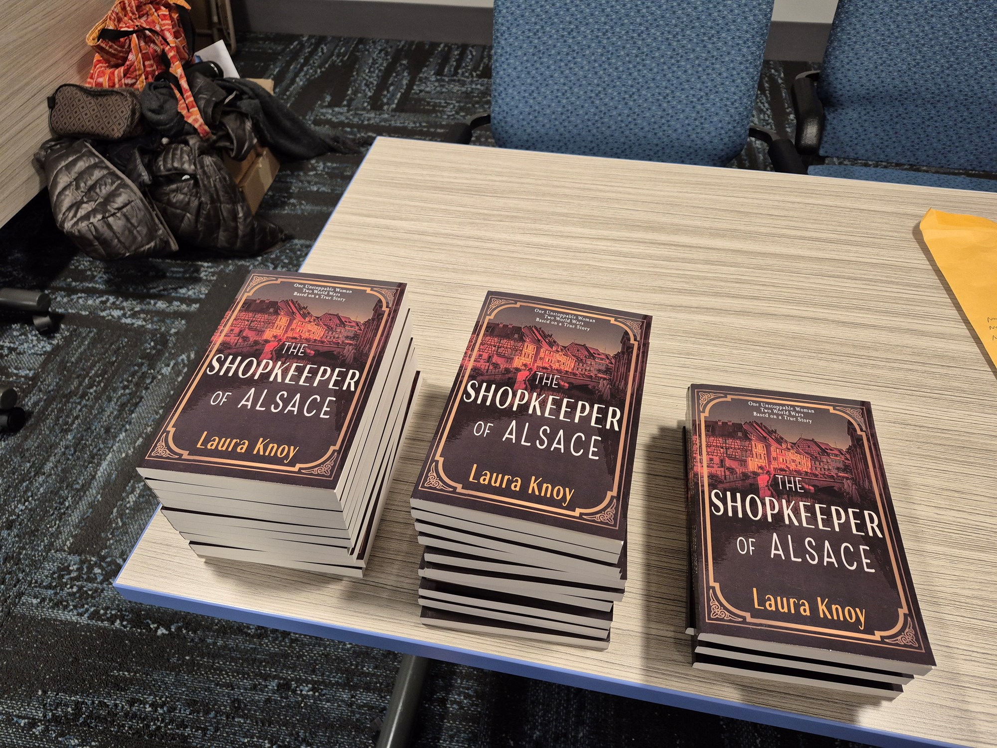 Copies of The Shopkeeper of Alsace on a table in the Meeting Room.